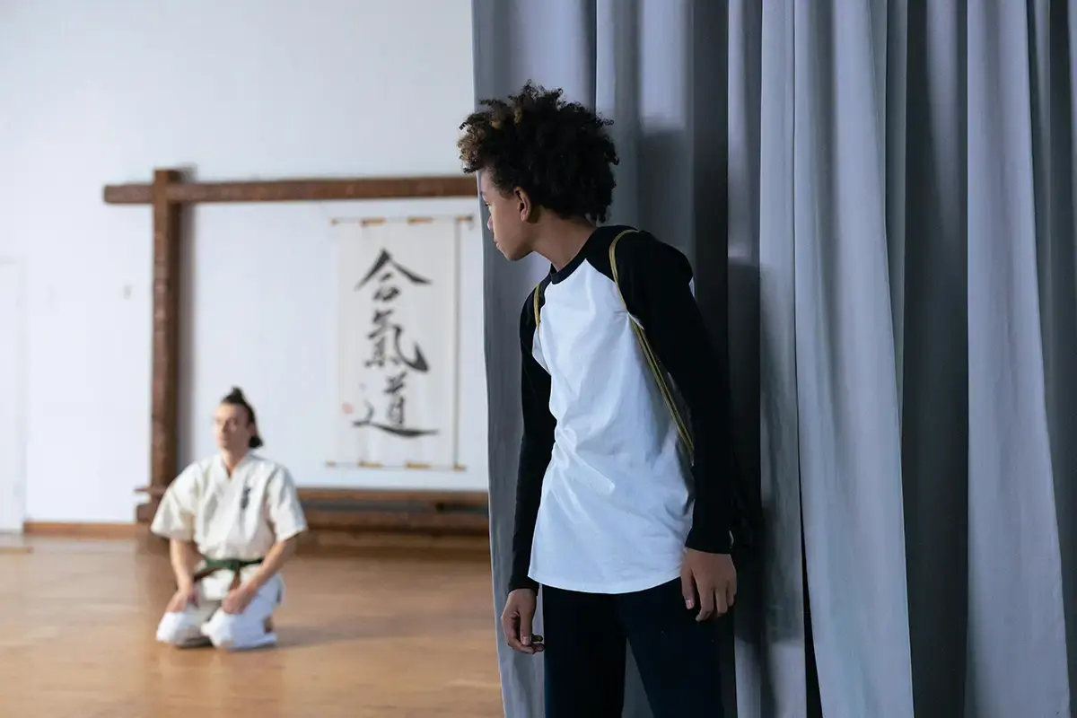 A student watching the Sensei demonstrate technique in the dojo
